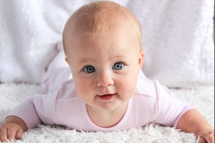 baby smiling on white carpet in Bellingham WA